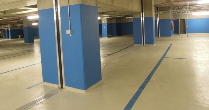 Mavi kolonlu otoparkta renklendirilmiş beton zemin