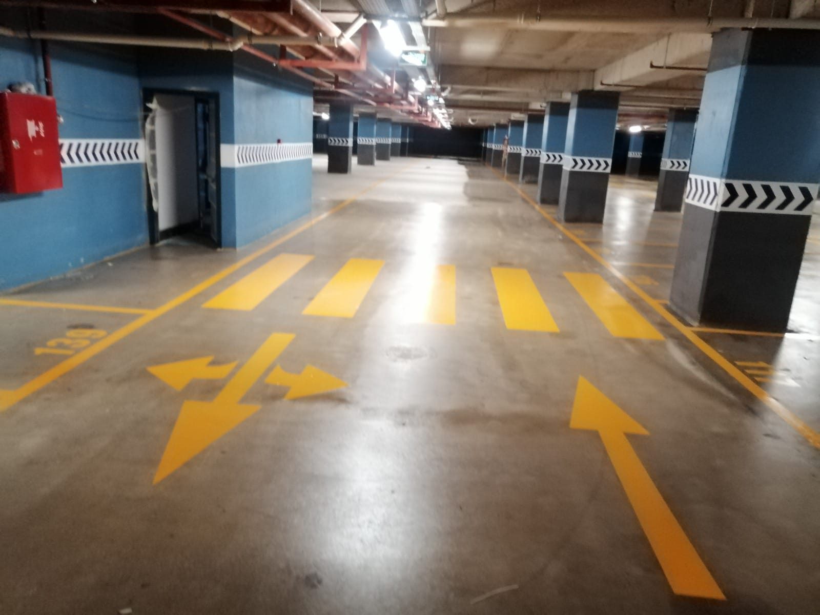 Mavi kolonlu otoparkta cilalı zemin ve yönlendirme okları